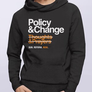 May include: Black hooded sweatshirt with white text that reads "Policy & Change" with a line through "Thoughts & Prayers" and the text "GUN. REFORM. NOW." below.