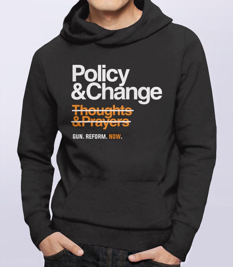 May include: Black hooded sweatshirt with white text that reads "Policy & Change" with a line through "Thoughts & Prayers" and the text "GUN. REFORM. NOW." below.