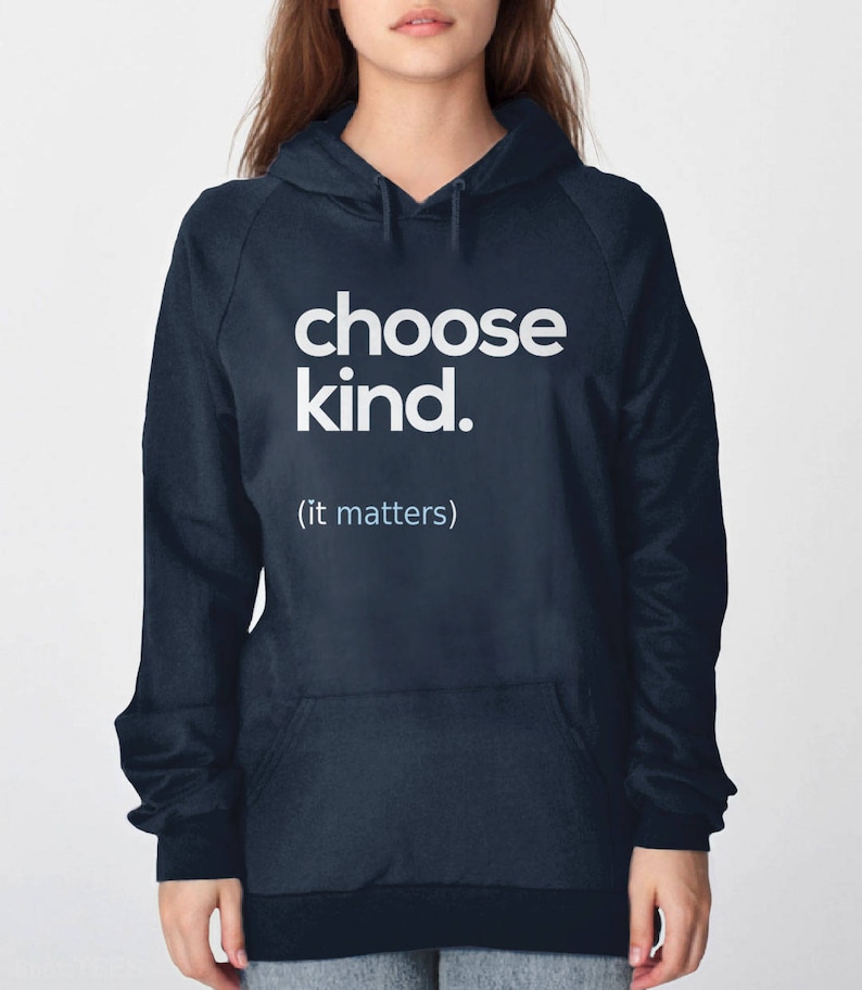 以下が含まれることがあります： 前面に「choose kind. (it matters)」という白い文字がプリントされたネイビーブルーのフード付きスウェットシャツです。