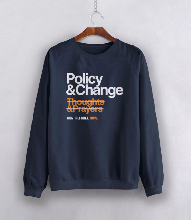 May include: Navy blue sweatshirt with a white graphic print that reads "Policy & Change" with a line through "Thoughts & Prayers" and the text "GUN. REFORM. NOW."