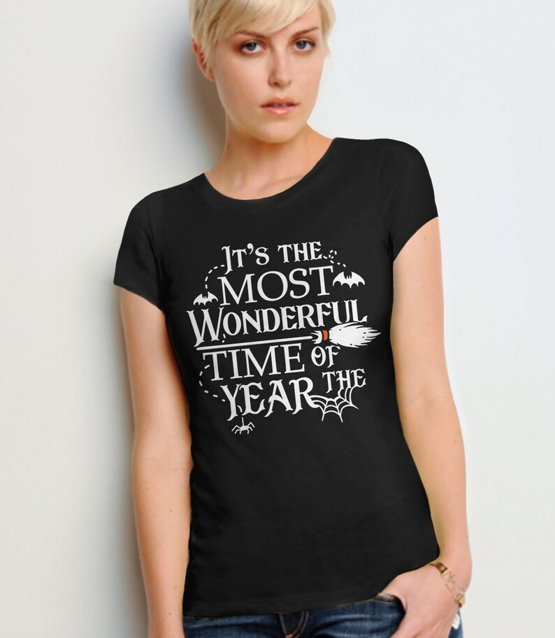 May include: Black t-shirt with white text that reads "It's the most wonderful time of the year" with a broom, bats, and spider web graphics.