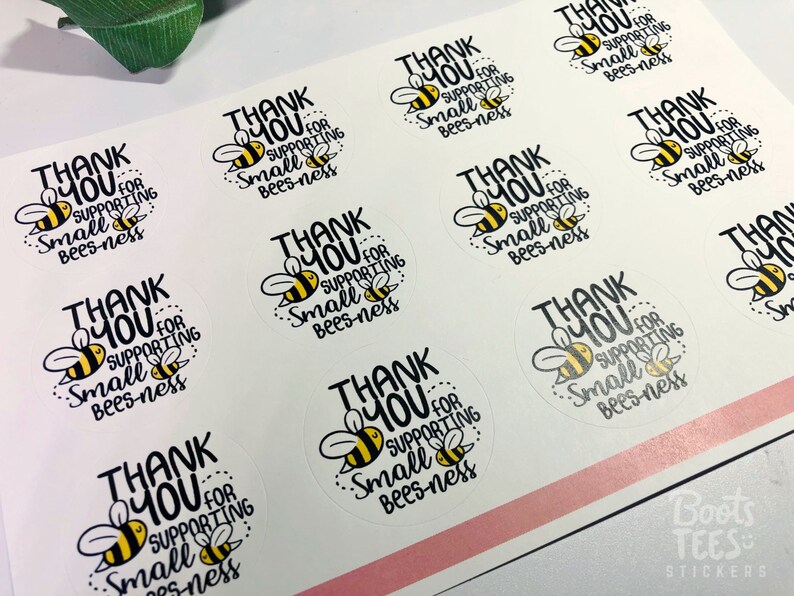 May include: A sheet of round stickers with a white background and black text that says "Thank You for Supporting Small Bees-ness". Each sticker features a cartoon bee with black and yellow stripes.