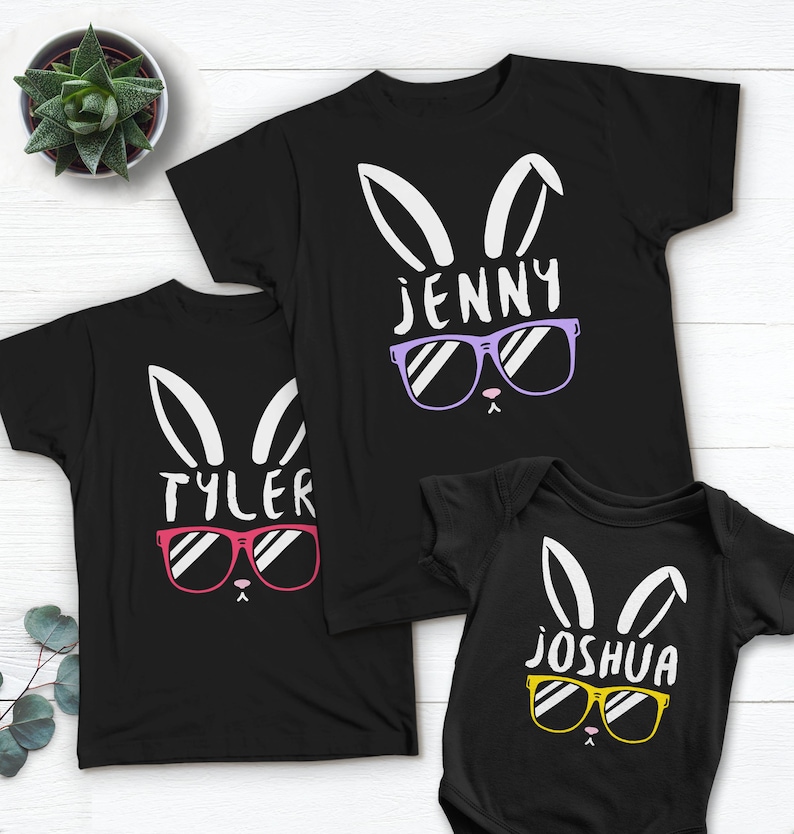 May include: Three black t-shirts with a bunny rabbit design wearing sunglasses. The shirts have the names "Jenny", "Tyler", and "Joshua" printed on them.