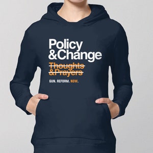 May include: A navy blue hoodie with a white graphic that says "Policy & Change" with a line through "Thoughts & Prayers" and the text "GUN. REFORM. NOW."