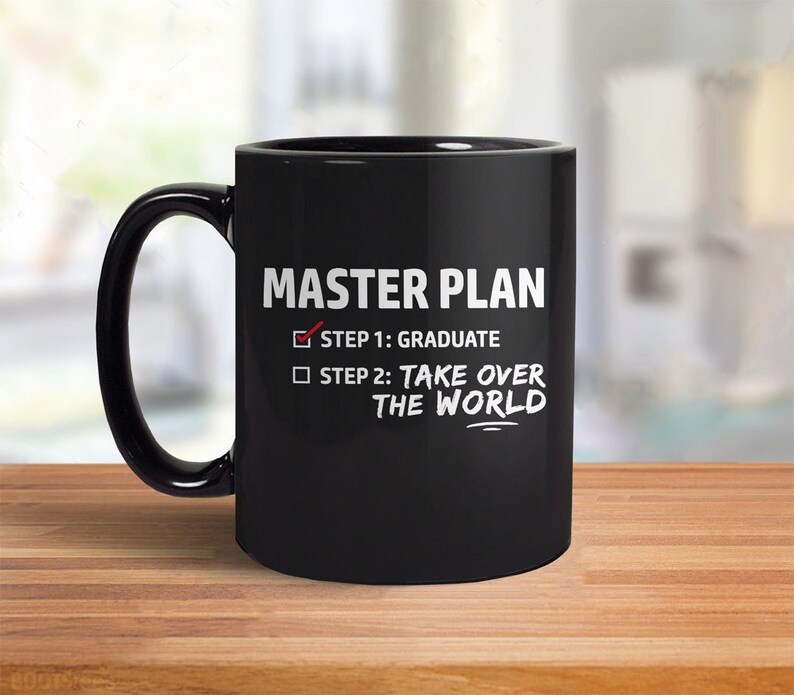 May include: Black coffee mug with white text that reads "MASTER PLAN" and a checklist with two items: "STEP 1: GRADUATE" with a checkmark and "STEP 2: TAKE OVER THE WORLD" with an empty box.