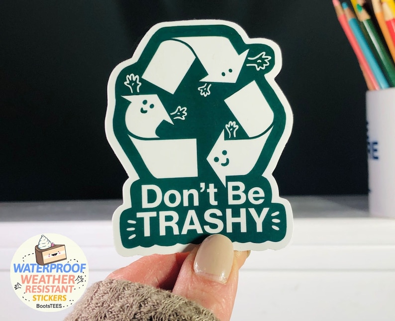 Op de afbeelding: Groene en witte sticker met een recycle-symbool en de tekst "Don't Be TRASHY".