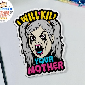 May include: A white sticker featuring a cartoon illustration of a woman with gray hair, fangs, and black tears. The text "I WILL KILL YOUR MOTHER" is written in yellow, blue, and pink.