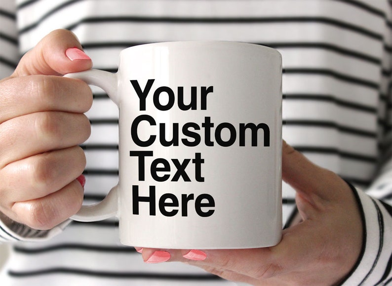 May include: White ceramic mug with a black handle. The mug has black text that reads "Your Custom Text Here".