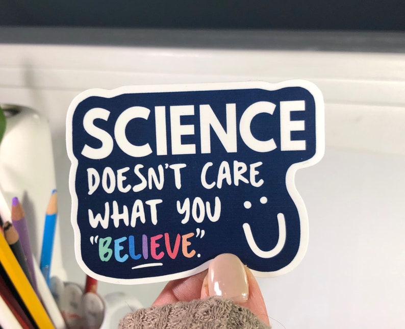 K&ouml;nnte beinhalten: Ein blauer Aufkleber mit wei&szlig;em Text, der "SCIENCE DOESN'T CARE WHAT YOU "BELIEVE"." lautet. Der Text "BELIEVE" ist in Regenbogenfarben.