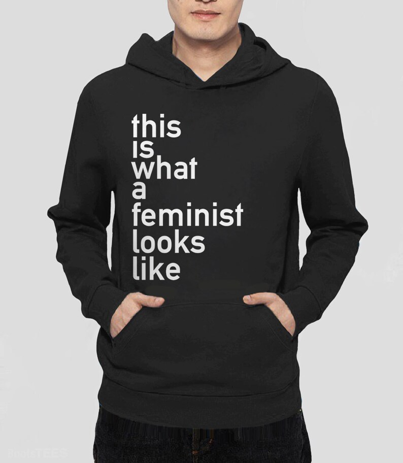 Pu&ograve; includere: Felpa con cappuccio nera con il testo "this is what a feminist looks like" in bianco.