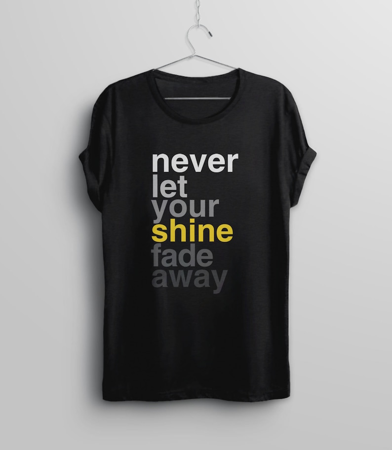 May include: Black t-shirt with the text "never let your shine fade away" in white and gray lettering. The word "shine" is in yellow.