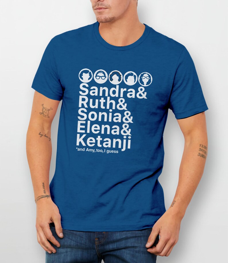 May include: A royal blue t-shirt with a white graphic of five female faces and the names Sandra, Ruth, Sonia, Elena, and Ketanji. The text *and Amy, too, I guess* is printed below the names.