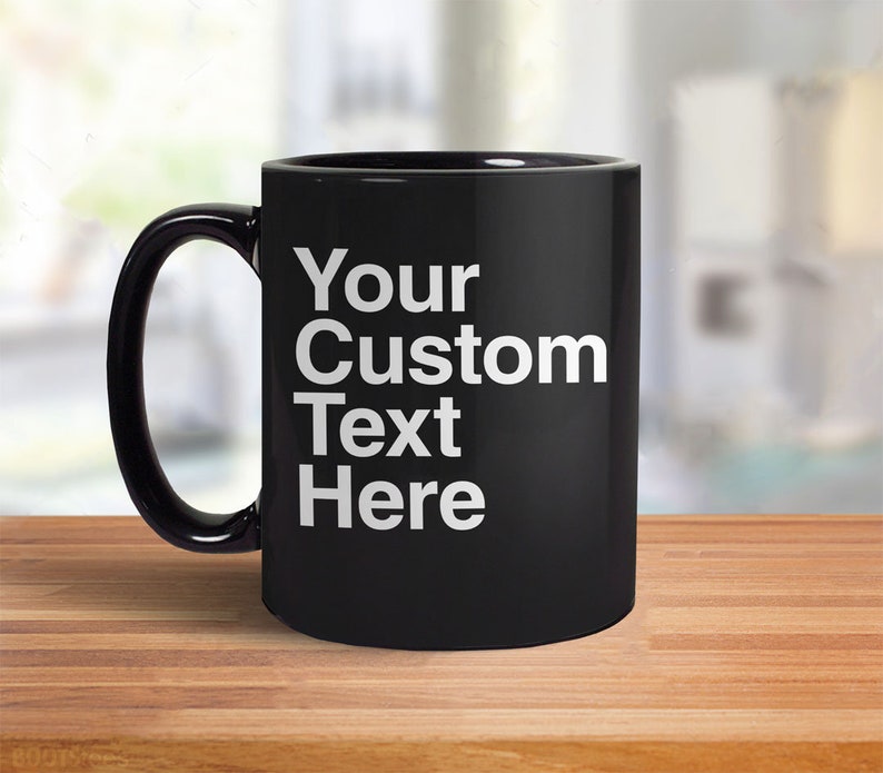 May include: Black ceramic coffee mug with a white inscription that reads "Your Custom Text Here".