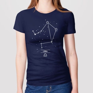May include: A navy blue t-shirt with a white outline of the Libra constellation and the word "LIBRA" and the Libra astrological symbol.