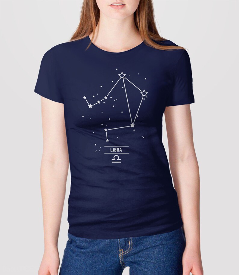 May include: A navy blue t-shirt with a white outline of the Libra constellation and the word "LIBRA" and the Libra astrological symbol.