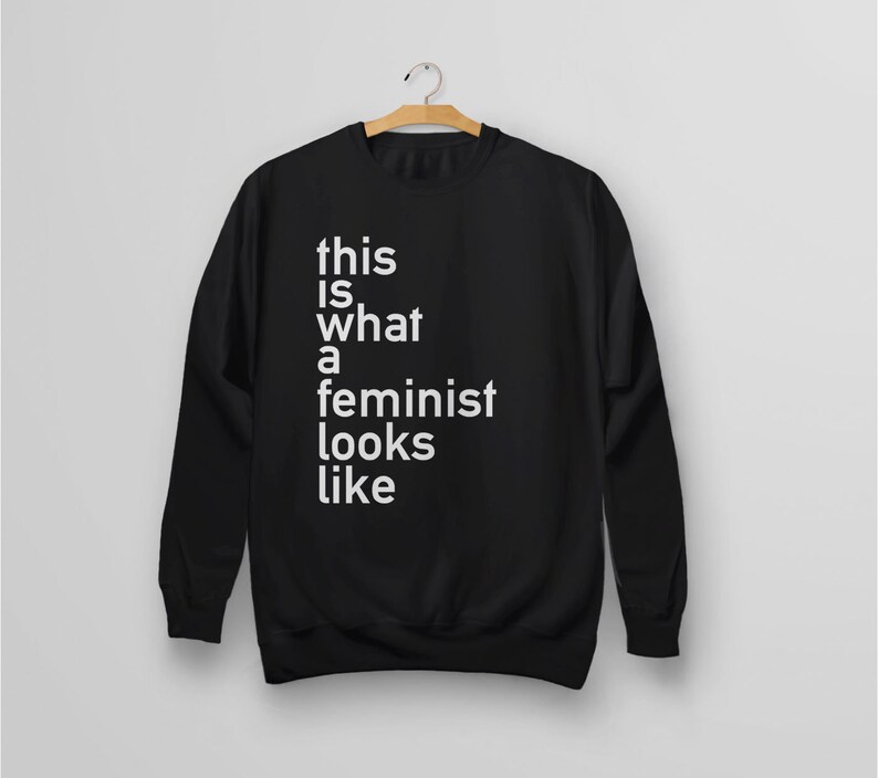 Pu&ograve; includere: Felpa nera con testo bianco che dice "this is what a feminist looks like".