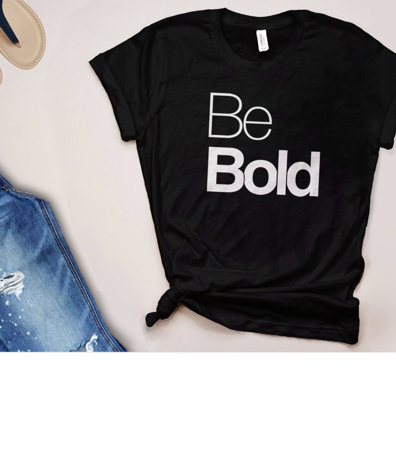 May include: Black t-shirt with white text that reads "Be Bold".
