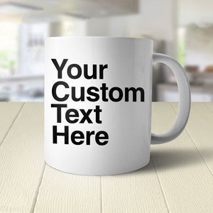 May include: White ceramic coffee mug with black text that reads "Your Custom Text Here".