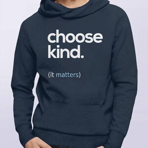 以下が含まれることがあります： 前面に「choose kind. (it matters)」という白い文字がプリントされたネイビーブルーのフード付きスウェットシャツです。