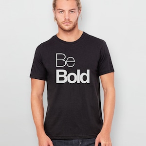 May include: A black t-shirt with the words "Be Bold" printed in white on the front.