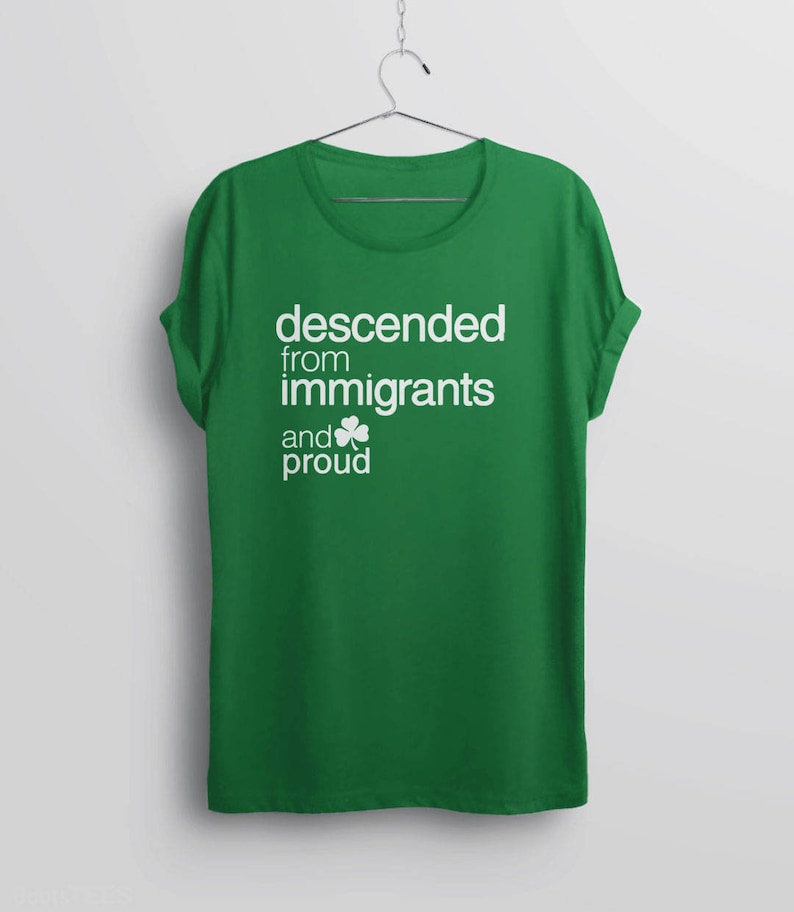 Pode incluir: Camiseta verde com texto branco que diz "descended from immigrants and proud" com um trevo branco.