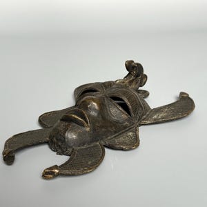 Low angle African bronze mask vintage tribal home decor handmade