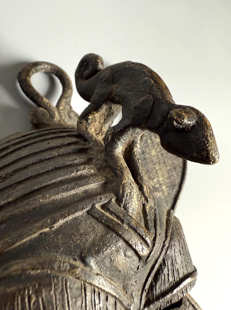 Bronze lizard detail on top of African tribal mask lost-wax cast