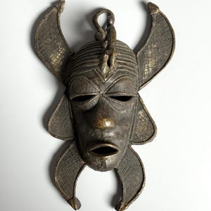 Close-up African bronze mask with detailed ornamentation ethnic handmade