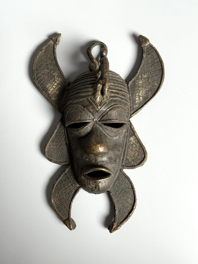 Close-up African bronze mask with detailed ornamentation ethnic handmade