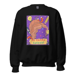 May include: Black sweatshirt with a vibrant graphic of a woman's hair, magnets, light bulbs, and a pencil. The graphic includes the text "MS. FRIZZLE ENERGY!" in a yellow banner. The design is set against a purple background with colourful dots.