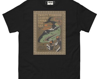 May include: Black t-shirt featuring a vintage illustration from Jules Verne's "Twenty Thousand Leagues Under the Sea." The design includes a large green sea creature, divers, and the book's title. The shirt has a classic crew neck and short sleeves.