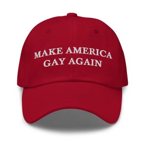 Könnte beinhalten: Rote Baseballkappe mit dem weißen, gestickten Text "MAKE AMERICA GAY AGAIN". Die Kappe hat einen gebogenen Schirm und ein klassisches Sechs-Panel-Design, geeignet für den lässigen Gebrauch.