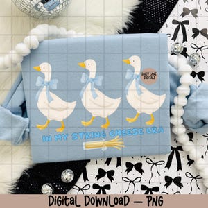 May include: Pale blue sweatshirt with a grid pattern, displaying three white geese adorned with blue bows. The text "IN MY STRING CHEESE ERA" is below the geese, with a string cheese graphic. The words "Digital Download - PNG" are at the bottom.