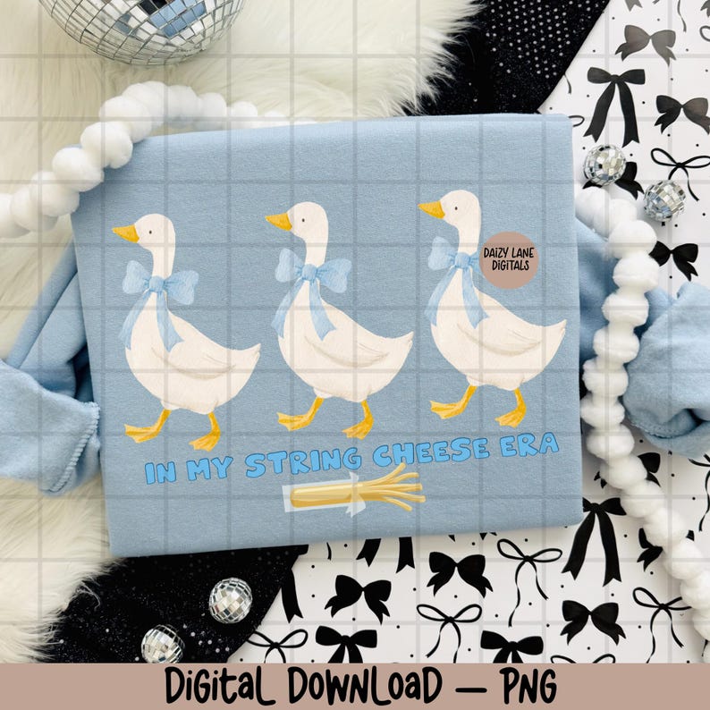 May include: Pale blue sweatshirt with a grid pattern, displaying three white geese adorned with blue bows. The text "IN MY STRING CHEESE ERA" is below the geese, with a string cheese graphic. The words "Digital Download - PNG" are at the bottom.
