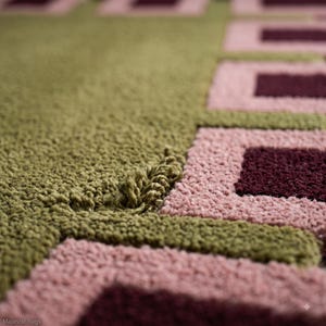Pu&ograve; includere: Un tappeto trapuntato con un motivo geometrico di quadrati verde oliva, rosa chiaro e bordeaux intenso. La superficie presenta una struttura a pelo riccio testurizzato con anelli di filato visibili e una finitura densa e morbida. Il testo Majestic Rugs &egrave; visibile.