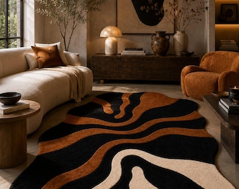 Può includere: Un tappeto dalla forma organica irregolare con un motivo astratto ondulato nei colori contrastanti nero, arancione bruciato e crema. Il tappeto presenta una superficie in pelo testurizzato e riporta la scritta MajesticRugs nell'angolo in basso.