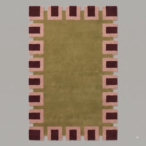 Pu&ograve; includere: Un tappeto rettangolare con un campo centrale color verde oliva a tinta unita. Il bordo presenta un motivo ripetitivo di rettangoli bordeaux scuro incorniciati da quadrati rosa chiaro, creando un profilo geometrico dentellato.
