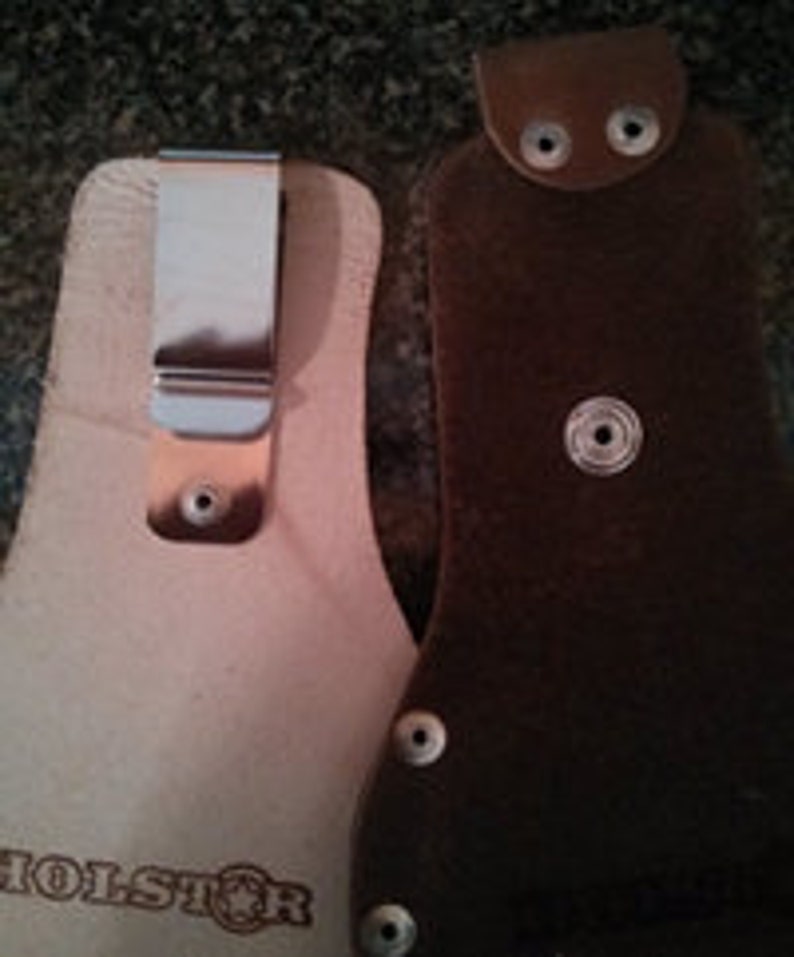 Op de afbeelding: Twee leren holster voor een zakmes of klein gereedschap. Een holster is van bruin leer met een metalen drukknoop sluiting. De andere holster is van lichtbruin leer met een metalen clip. Beide holster hebben het woord "HOLSTER" in het leer gegraveerd.