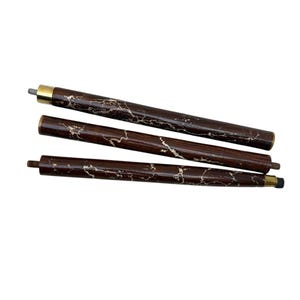 May include: Three-piece wooden cane shaft with a dark brown finish and a marbled, light-colored pattern. The cane sections have brass-colored metal accents and threaded ends for assembly. The cane is designed for mobility and support.