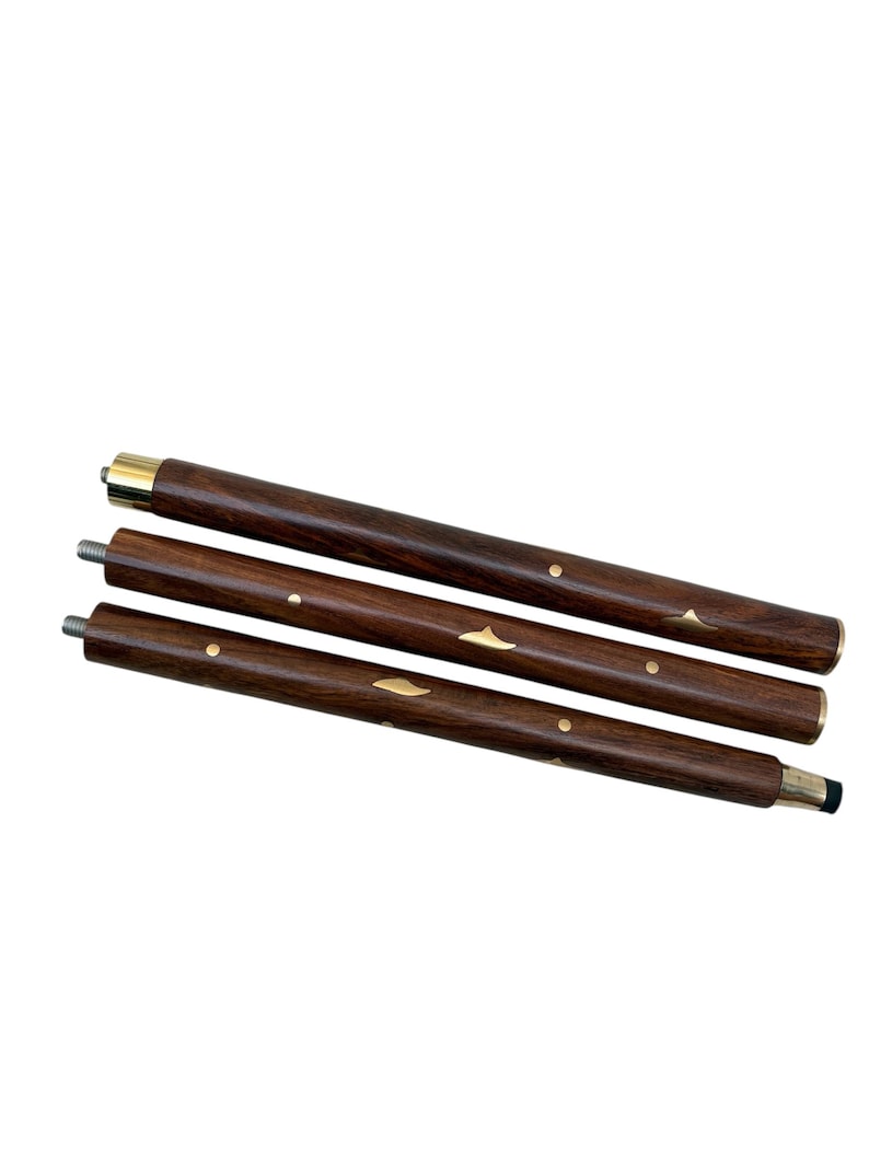May include: Three-piece wooden walking cane with a dark brown finish. The cane features brass accents and metal screw threads for assembly. The top and bottom sections have brass-colored metal bands.