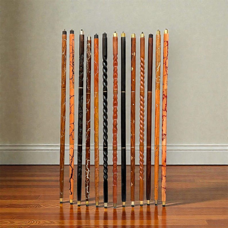 May include: A collection of wooden walking canes with various designs. The canes feature different colors and patterns, including swirls, cracks, and solid colors. Each cane has a brass tip and a handle. The canes are standing upright on a wooden floor.