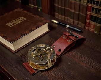 Orologio da polso nautico vintage in ottone con meridiana, bussola e cinturino in pelle.
