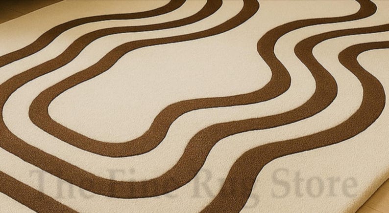 K&ouml;nnte beinhalten: Ein beiger Teppich mit einem sich wiederholenden Muster aus wellenf&ouml;rmigen, braunen Linien. Die Linien sind dick und erzeugen ein flie&szlig;endes Design auf der Oberfl&auml;che des Teppichs. Der Teppich hat ein weiches, strukturiertes Aussehen.