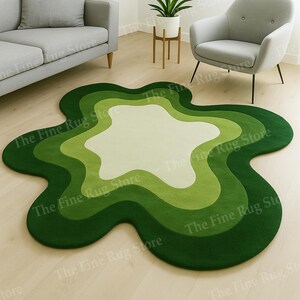 May include: A green, flower-shaped rug with varying shades of green and a white center. The rug is on a light-coloured wooden floor. The Fine Rug Store is printed on the image.