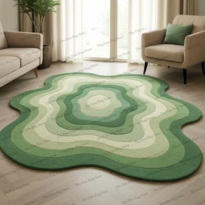 Puede incluir: Una alfombra verde de forma abstracta con un dise&ntilde;o en capas. La alfombra presenta l&iacute;neas conc&eacute;ntricas y onduladas en diferentes tonos de verde, creando un patr&oacute;n &uacute;nico y org&aacute;nico. Esta cubierta de suelo decorativa a&ntilde;ade un toque moderno.