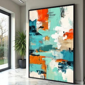 May include: Abstract art painting with a black frame. The artwork features bold brushstrokes in shades of orange, teal, white, and navy blue. Vertical black lines add contrast. The painting is displayed in a bright, modern interior setting.
