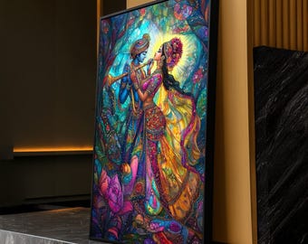 Puede incluir: Una obra de arte enmarcada que representa una escena vibrante de dos figuras con vestimenta tradicional india. Las figuras están rodeadas de exuberante follaje y flores, con una paleta de colores brillantes. Una figura toca una flauta, mientras que la otra lleva un tocado floral.