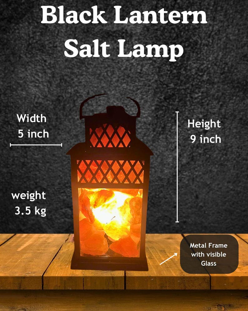 K&ouml;nnte beinhalten: Schwarze Laternen-Salzlampe mit Metallrahmen und sichtbarem Glas. Die Lampe ist 23 cm hoch und 13 cm breit und wiegt 3,5 kg. Die Lampe enth&auml;lt orangefarbene Salzkristalle und tr&auml;gt den Text "Black Lantern Salt Lamp".