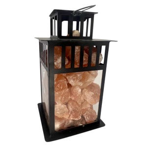 K&ouml;nnte beinhalten: Schwarze Metalllaterne gef&uuml;llt mit rosa Himalaya-Salzbrocken. Die Laterne hat eine rechteckige Form mit einem Griff oben und einer transparenten Glasscheibe, um das Salz zu pr&auml;sentieren. Die Salzbrocken sind in verschiedenen Gr&ouml;&szlig;en und Formen.
