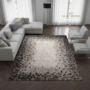 Peut inclure: Un tapis rectangulaire présentant un motif pixélisé en dégradé composé de carreaux carrés dans des tons de blanc, gris et noir. Le tapis est placé dans une pièce avec un canapé d'angle gris clair, deux fauteuils gris clair et le texte SN ALEF HOME.